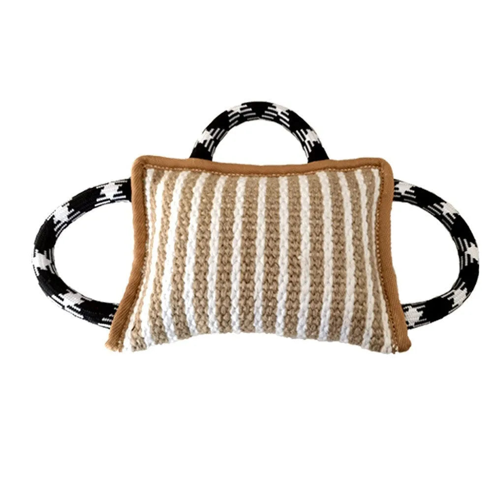 Dog tug of war toy with blue jute bite pillow and three rope handles on a wooden floor.