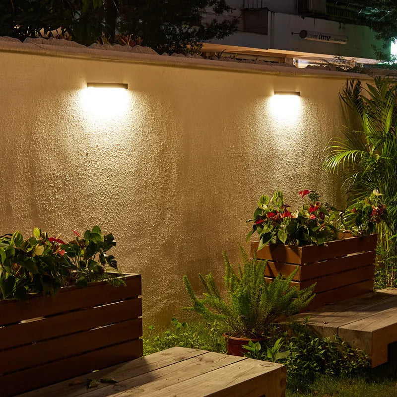 Black solar-powered outdoor wall lamp with IP65 rating for garden installation