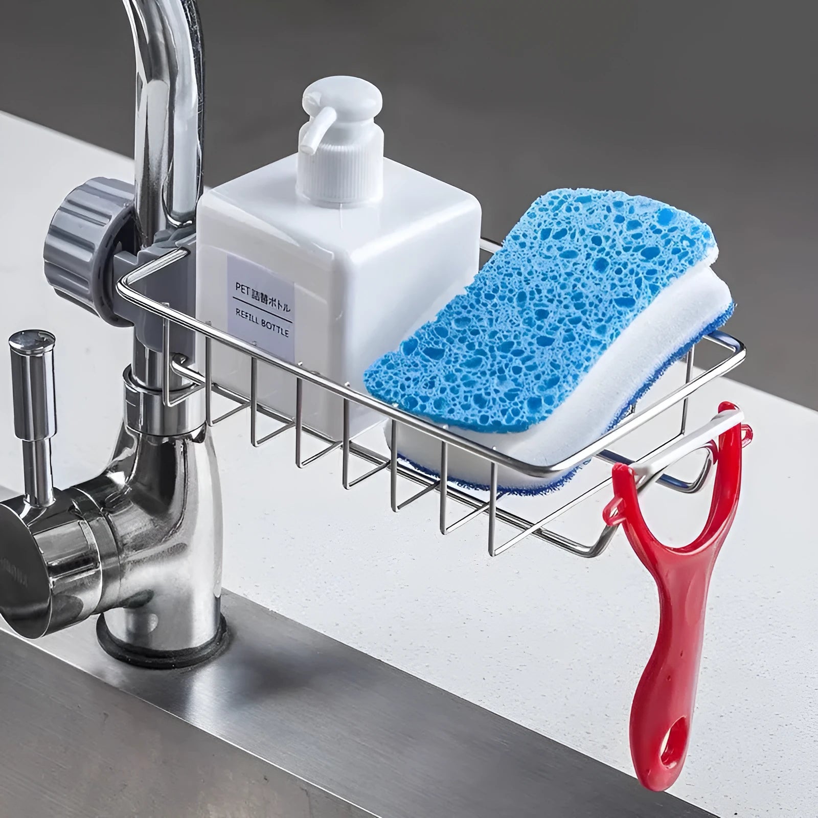 Adjustable stainless steel sink drain rack clipped onto a kitchen faucet with sponge and soap stored on the removable holder