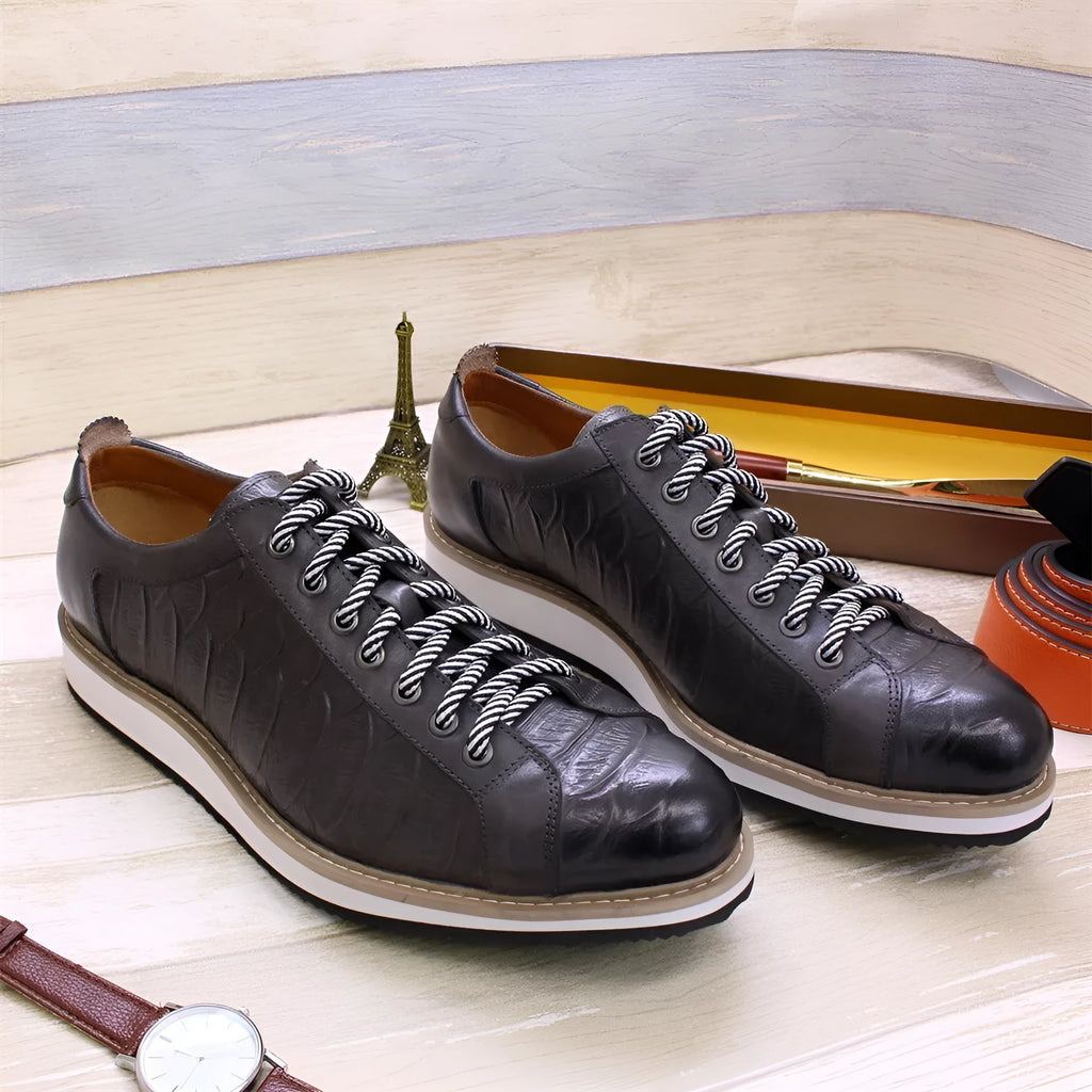 Men's low-top handmade shoes with embossed pattern on front, showing front-tie laces and grey colour.