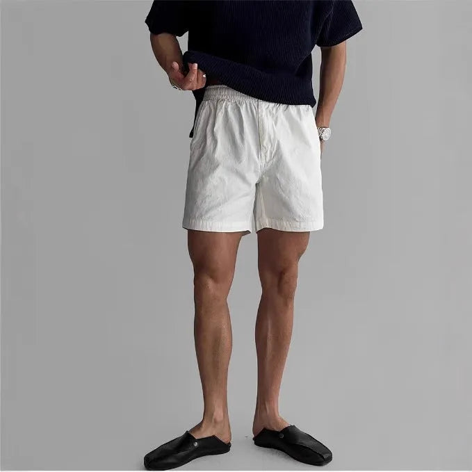 Man's loose-fit cotton sports shorts in black, showing elastic waistband with drawstring.