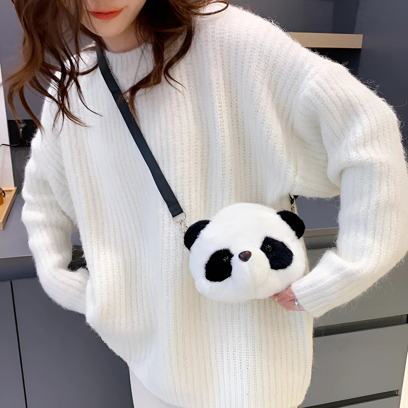 Soft plush crossbody bag in panda head colour with cylindrical shape and sandwich pocket.