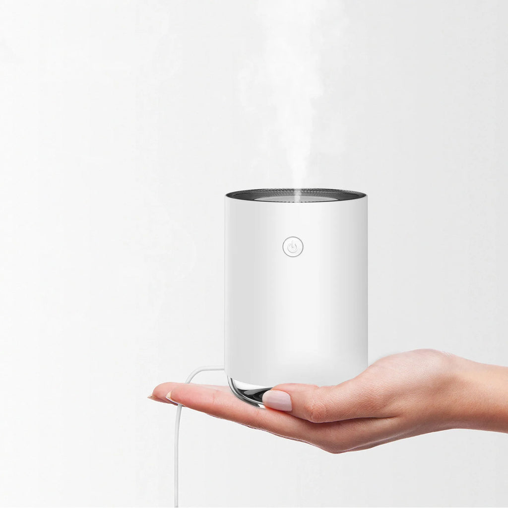 White, pink, or green night light humidifier and essential oil diffuser unit on a bedside table