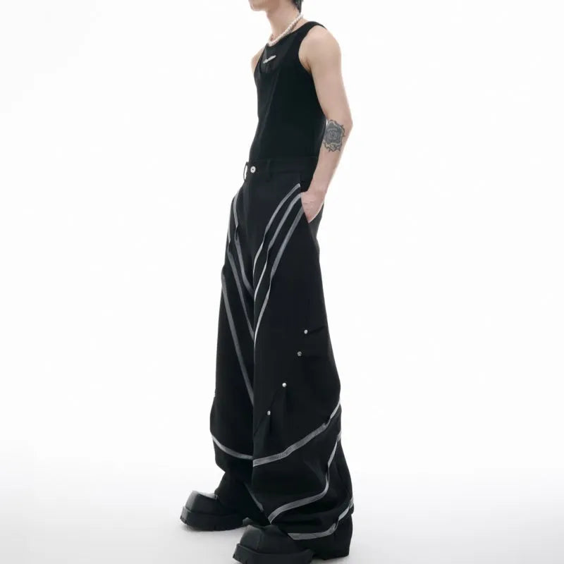 Men's black polyester trousers with three-dimensional cut and metal striped rivets on the pleats.