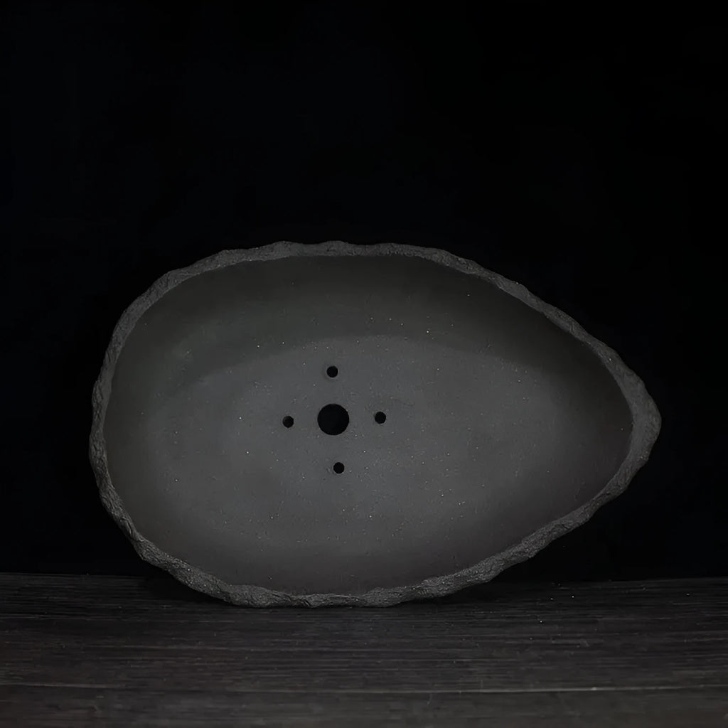 Handmade purple clay flower pot showing natural texture and colour variations
