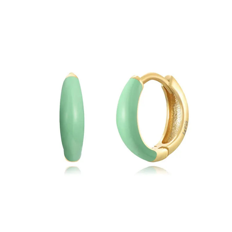 A pair of curved U-shaped epoxy earrings with a translucent blue dripped oil finish and a silver hook on a white background.
