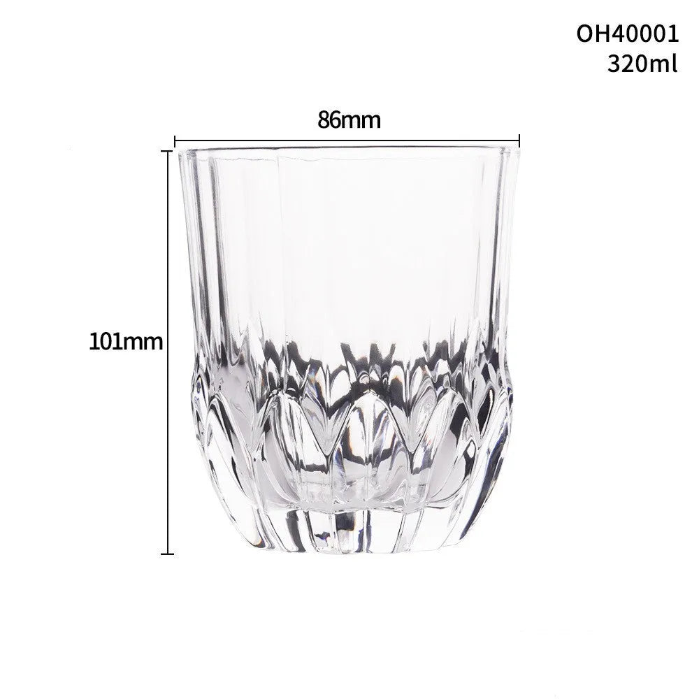 Clear crystal whiskey shot glass with thick bottom base on a table.