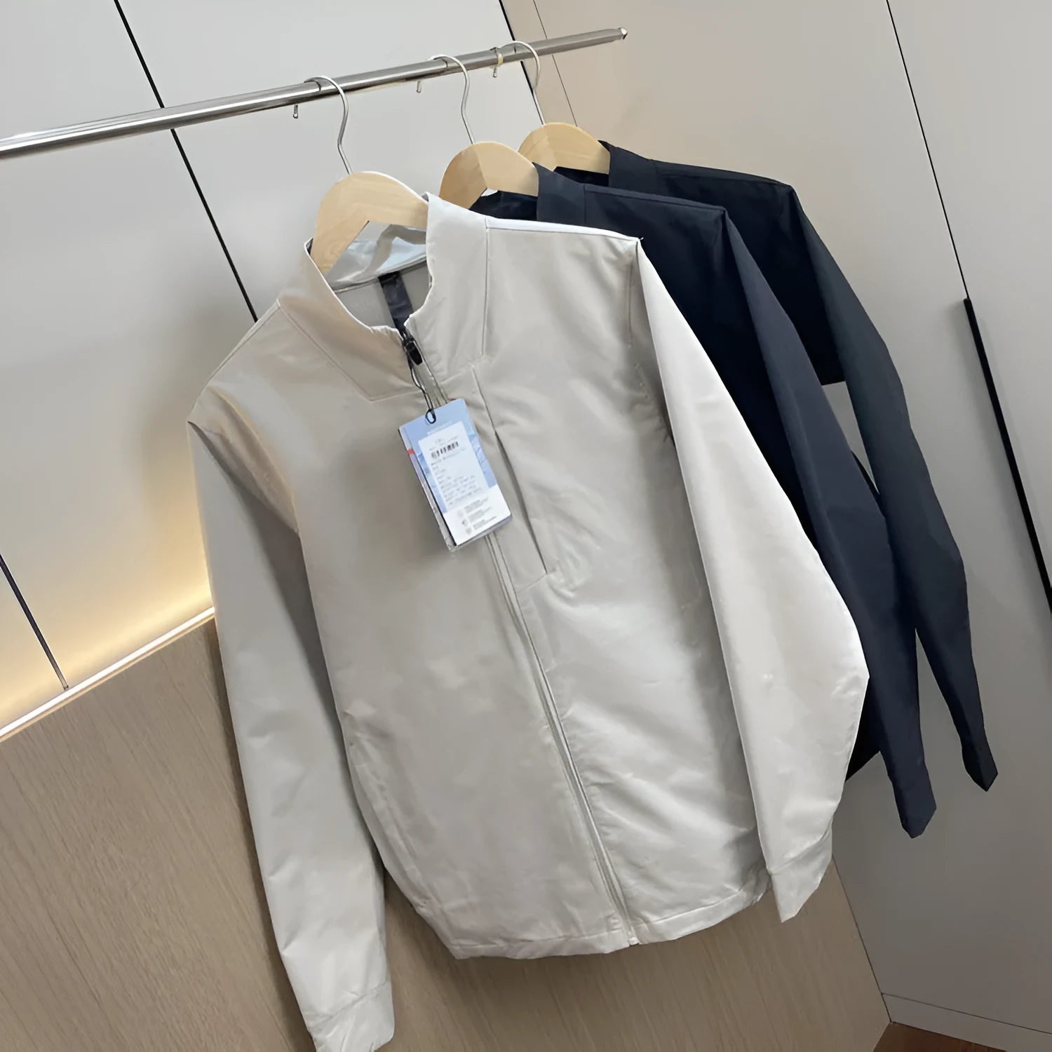 Men's stand collar casual jacket in polyester, shown in black, dark blue, or milky white.