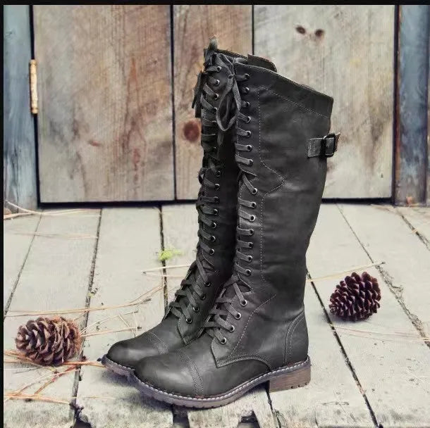 Black women's high-leg boot with a chunky low heel and round toe on a plain background.