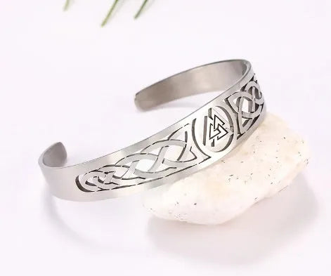 Handcrafted stainless steel bracelet with Valknut symbol and Celtic design on a neutral background
