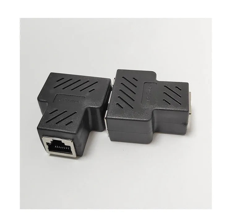 Two white RJ45 three-way tee network cable splitters on a dark surface.