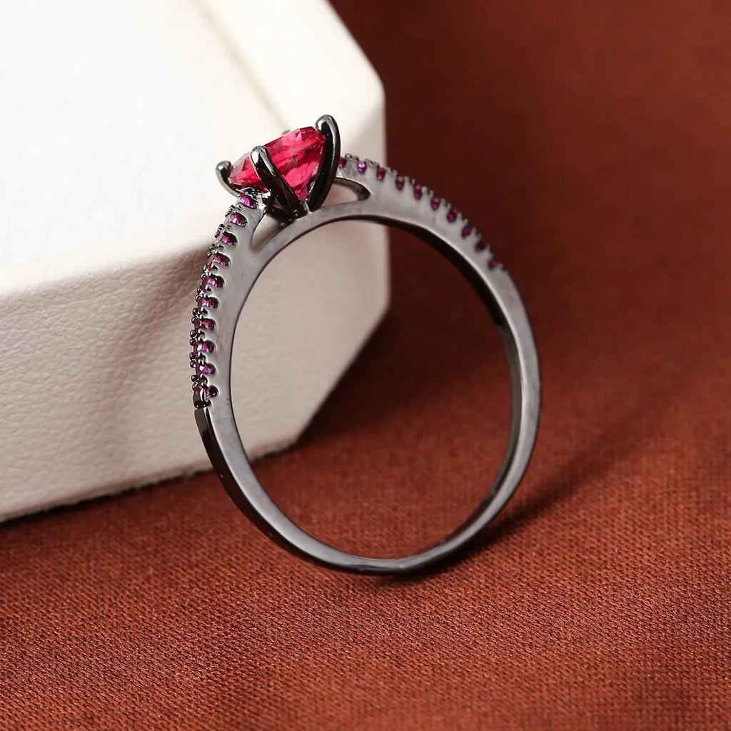 A geometric hexagon-shaped copper ring in a gun black and purple electroplated finish, shown from the side.