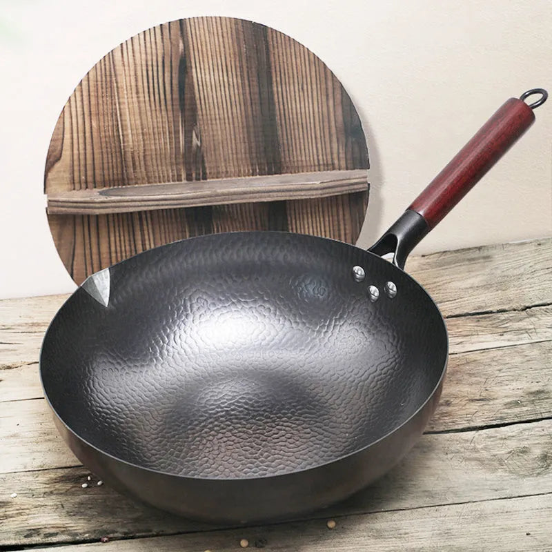 Traditional black iron wok with wooden handle, 40cm diameter, showing induction-compatible flat base