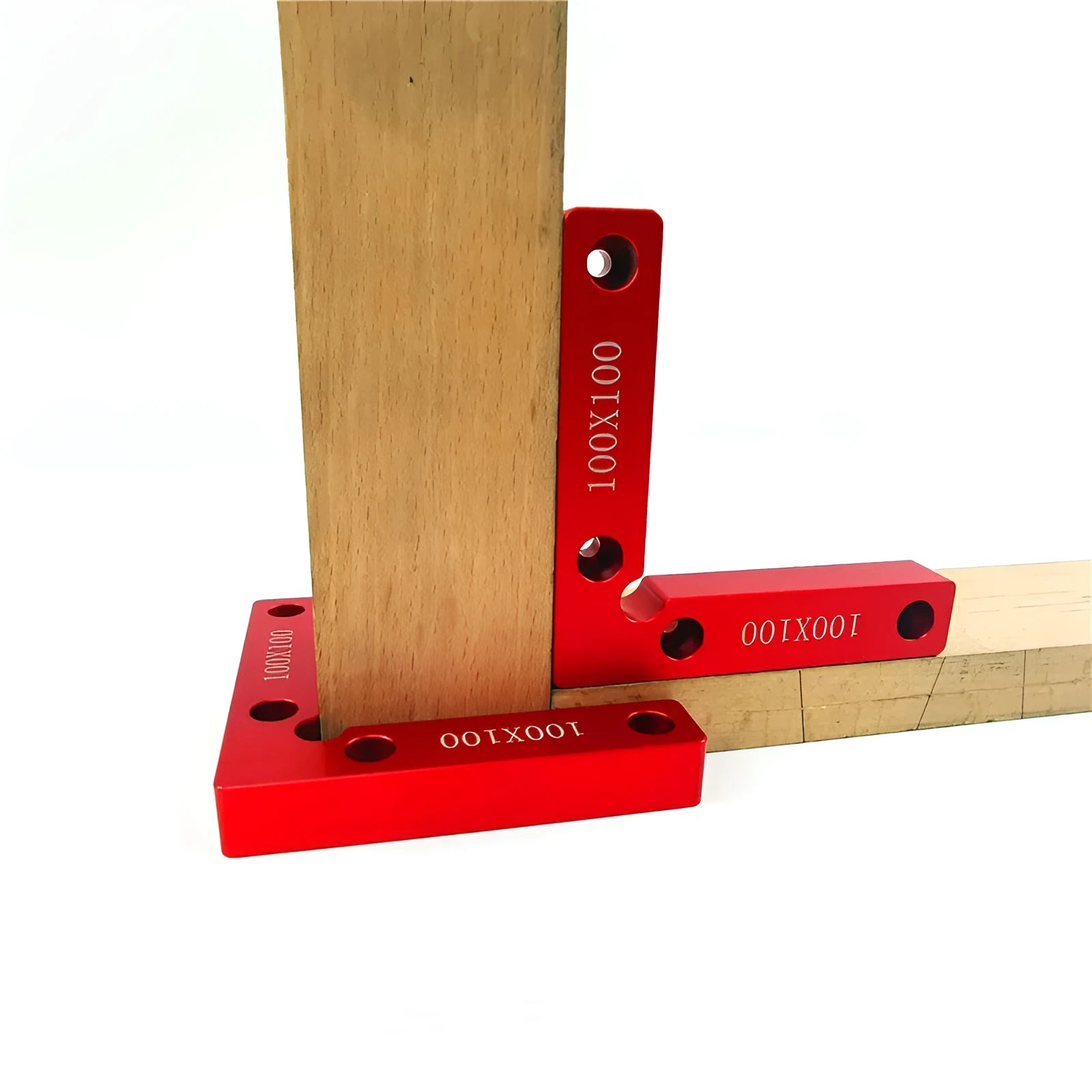 Silver aluminium right angle block clamped to a wooden workbench next to a jigsaw, showing scale markings.