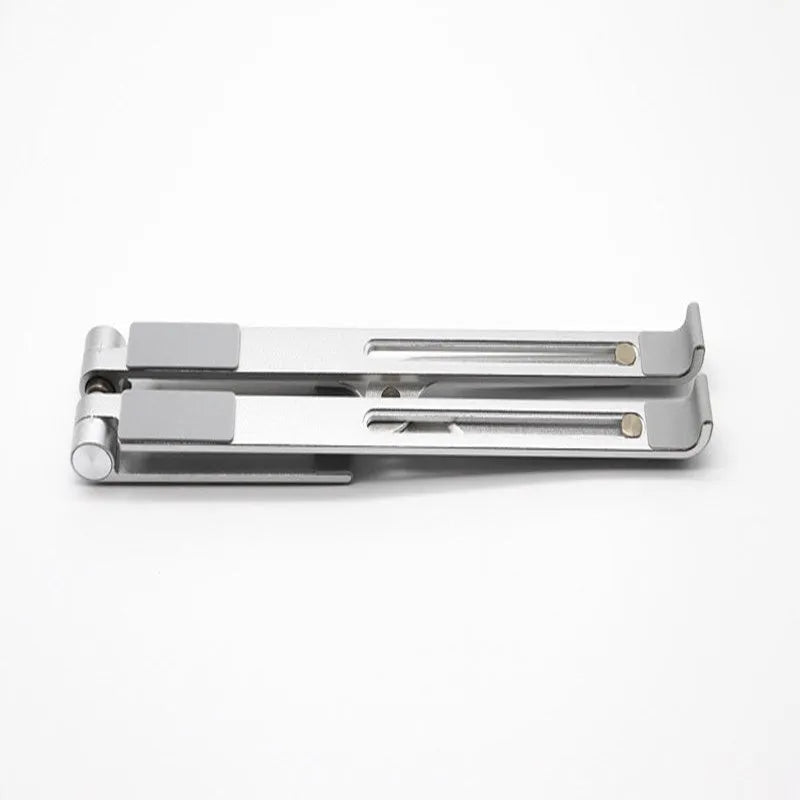 Black aluminium notebook stand supporting a silver laptop on a desk.