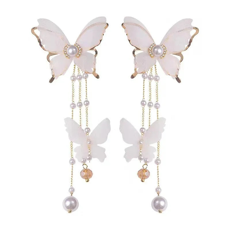 White butterfly-shaped tassel earrings with pearls and sparkling rhinestones on a copper alloy base.