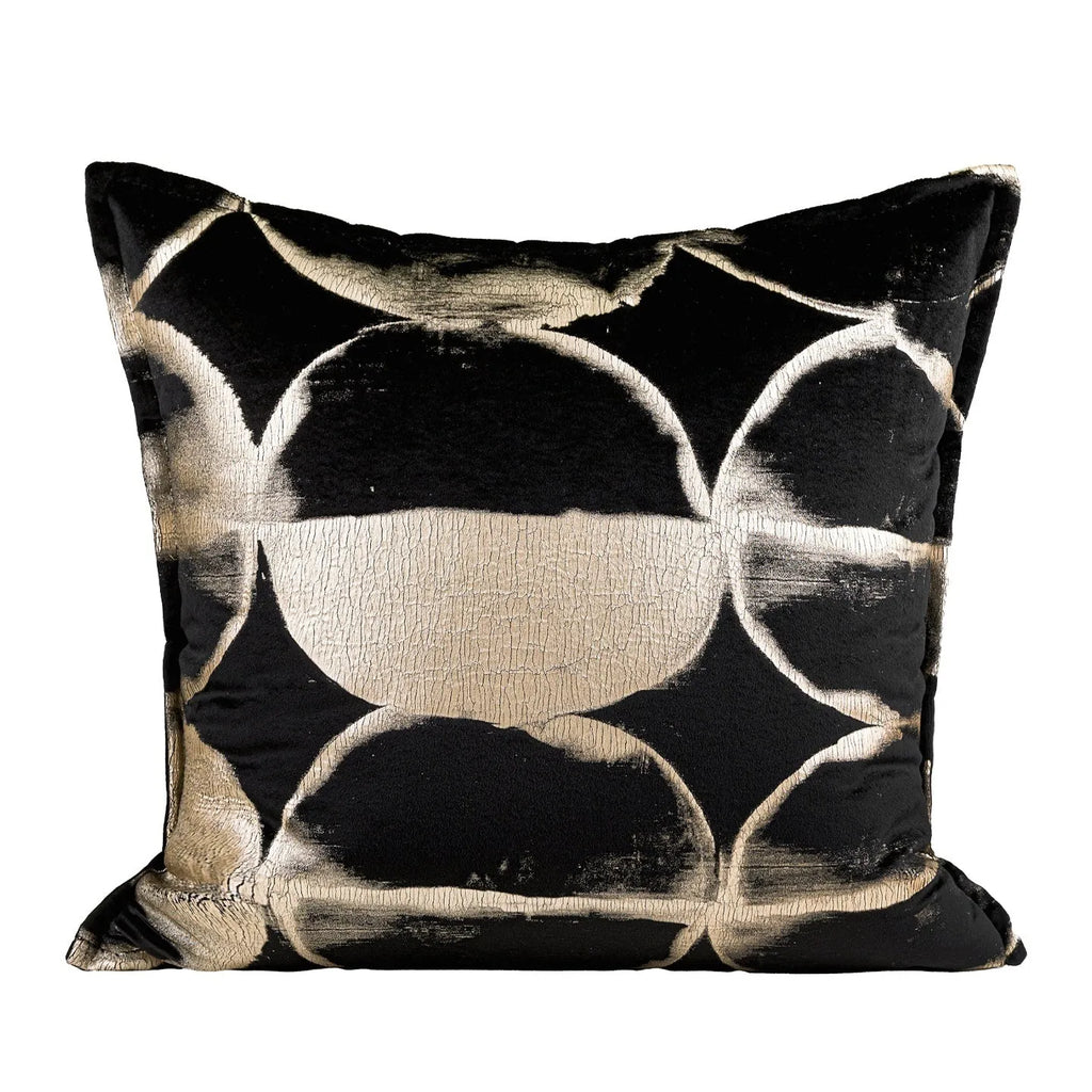 Black and gold abstract pattern decorative square and waist pillow cushions on a grey sofa.