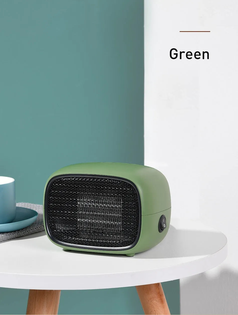 Green mini portable heater with dimensions 158mm x 90mm x 114mm on a wooden desk.