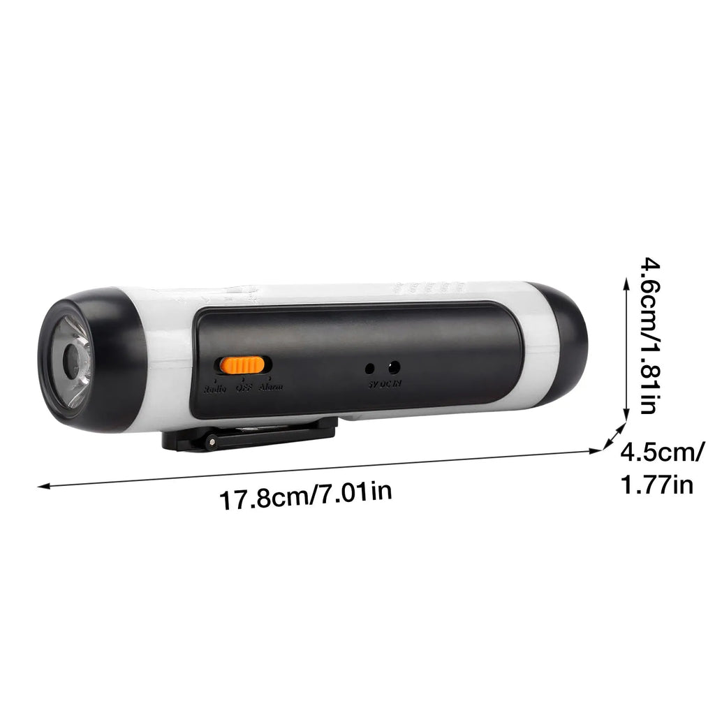 Orange emergency FM rechargeable alarm flashlight with hand crank on a dark outdoor background