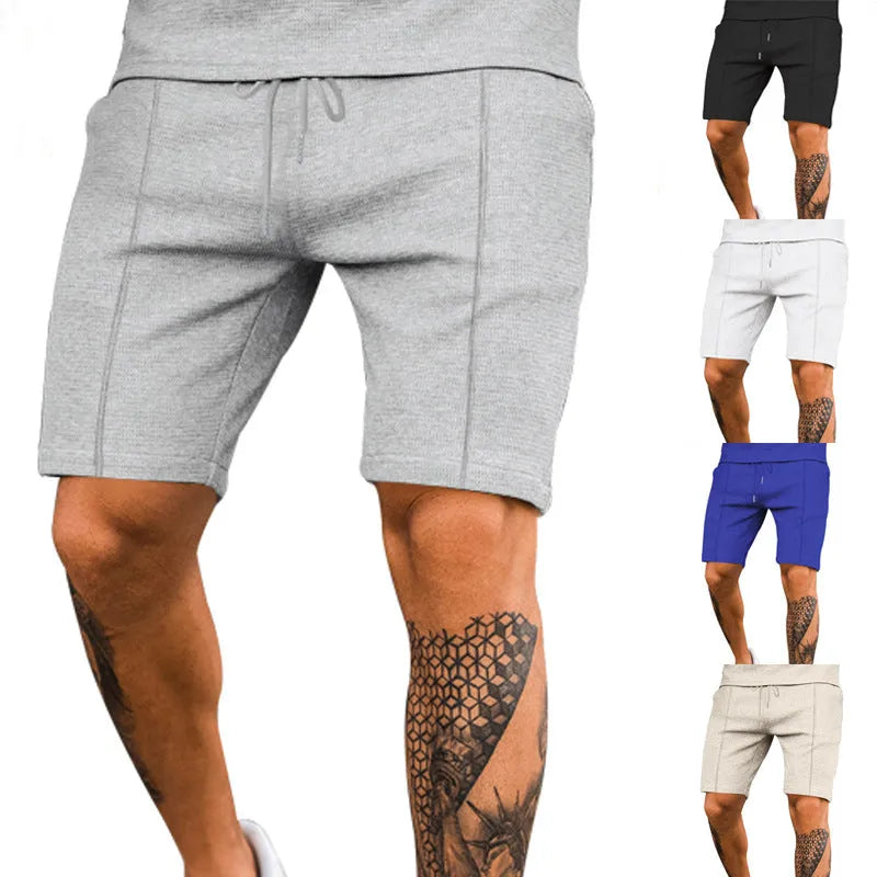 Solid colour five-point polyester sports shorts in khaki with elastic waistband, side view on model