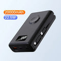 Black wireless power bank with charging bracket showing display screen and multiple USB ports