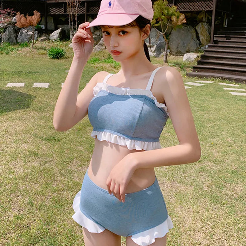 Solid-colour women's one-piece swimsuit with fashionable suspender straps, conservative cut.