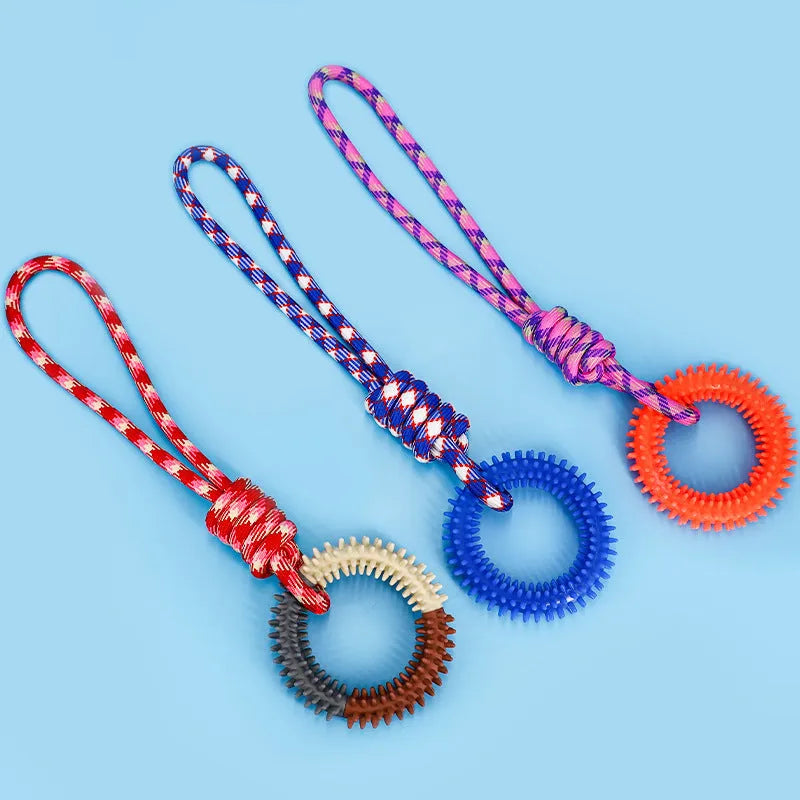 Blue, red, and rose red braided rope dog toy with a large central knot.