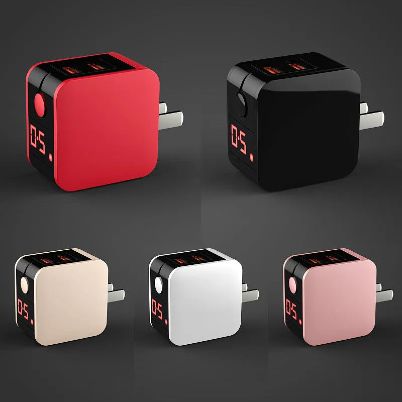 Black dual USB fast charger with digital display showing voltage and current, next to UK plug