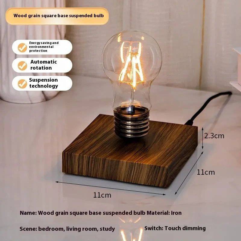 Small black suspension bulb desk lamp with iron art body on a wood grain base.