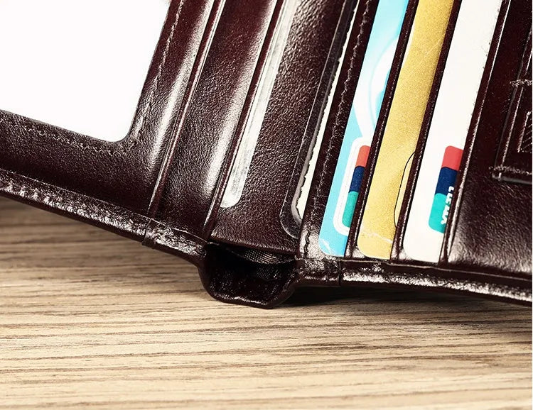 Men's black leather bifold wallet open, showing eight card slots, bill compartment, and a zip coin pocket