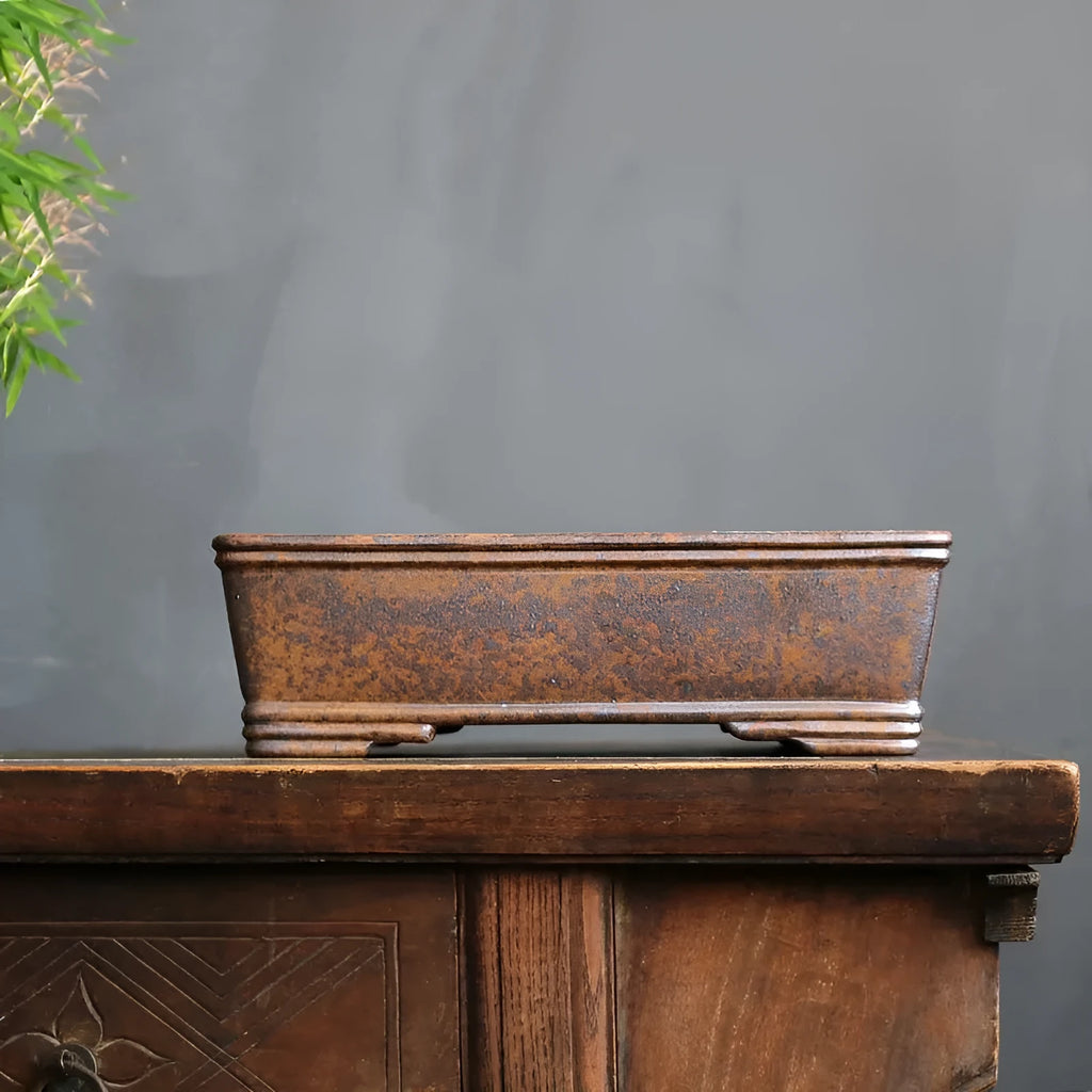 Rectangular purple sand bonsai pot with rustic firewood-burned texture, shown empty on a wooden surface.
