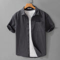 Man wearing a loose fit light blue pure cotton short sleeve button-up shirt