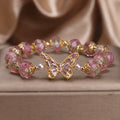 Pink crystal cherry blossom butterfly bracelet with hollow zircon accents on white background