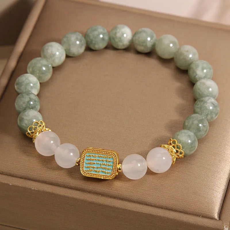 Close-up of a women's oil green emerald crystal bracelet featuring a five-piece sutra design.