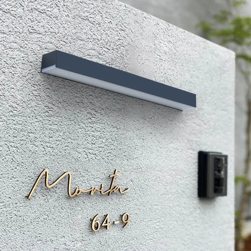 Black solar-powered outdoor wall lamp with IP65 rating for garden installation