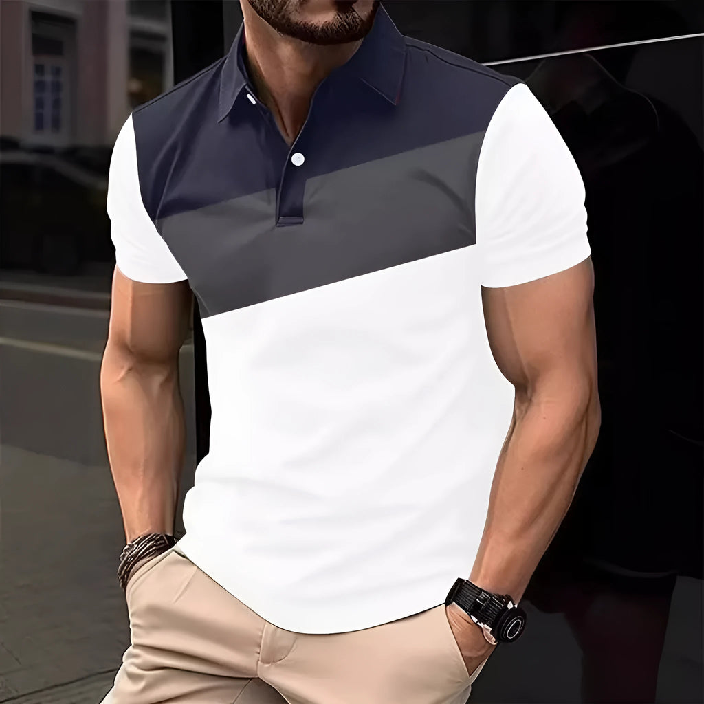 Man wearing a loose fit grey T-shirt with a colourful 3D digital graphic print on the front.