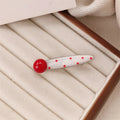 Red handmade hair clip shaped like a 3D love heart with vintage white dots, on a white background.