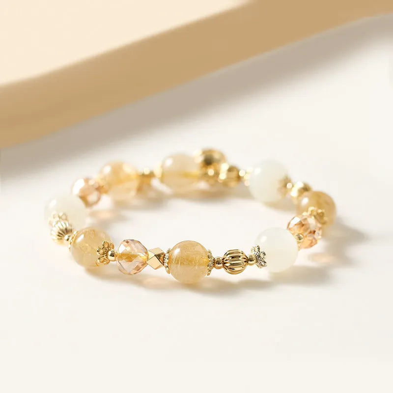 Gold rutilated quartz crystal bracelet with a ringing bell charm in Korean style.