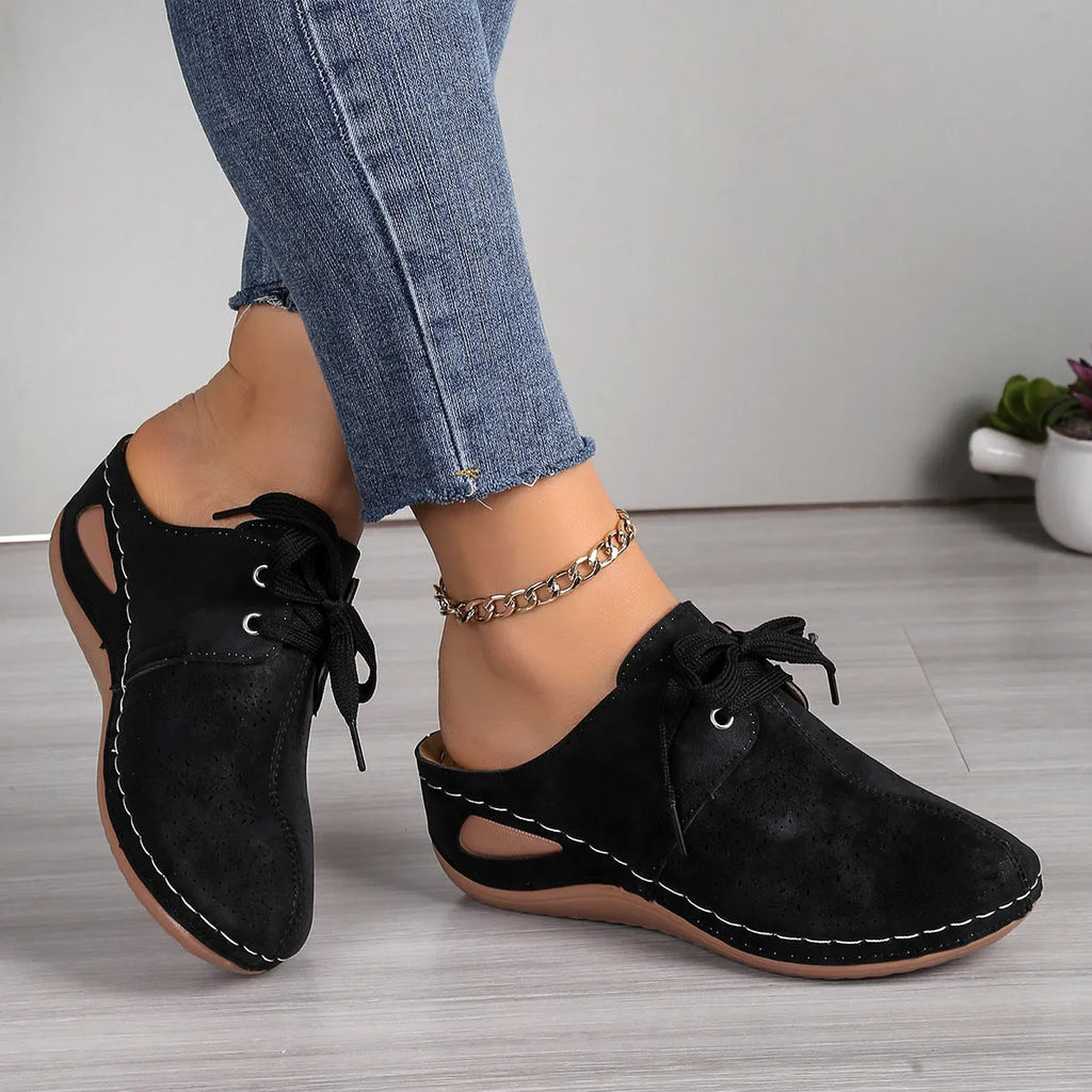 Women's black suede lace-up wedge slippers with hollow-out design and rubber sole.