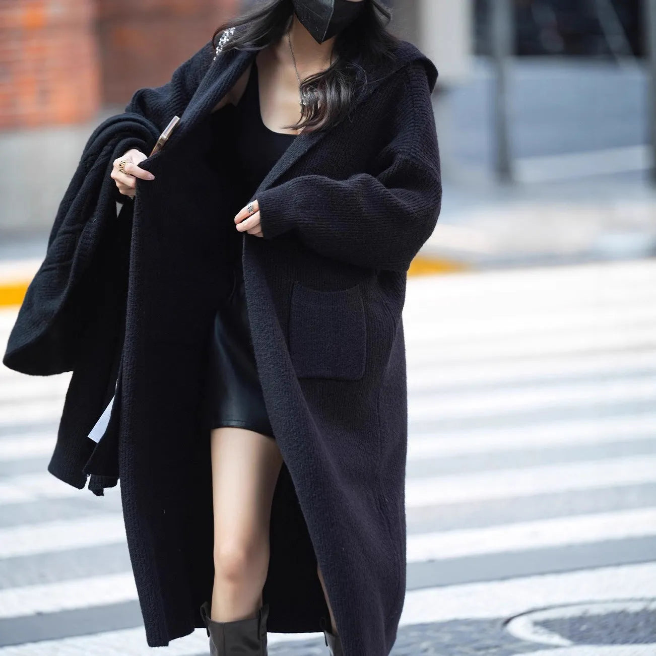 Long grey knitted cardigan coat with long sleeves on a hanger.