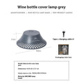 Beige rechargeable wine bottle shaped camping lantern with USB-C port and switch, shown illuminated.