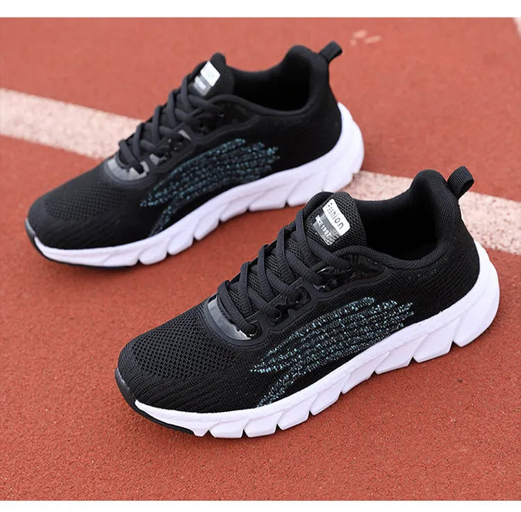 Low-top black and white running sneakers with cross-strap detail and flat MD sole.