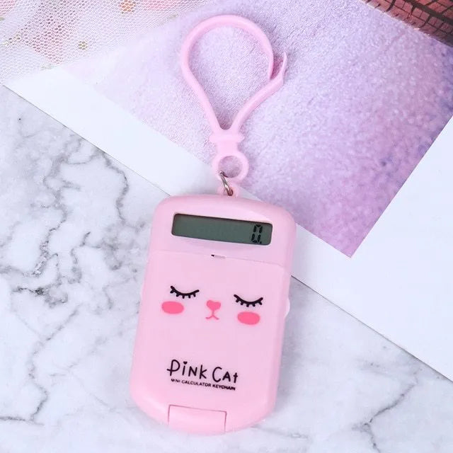 Creative cookie-shaped cute mini calculator in pink with key ring on a white background