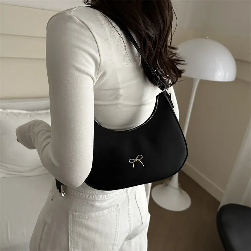 Women's underarm small shoulder bag in dumpling shape, shown in one of six colours: white, black, pink, khaki, brown, or silver.