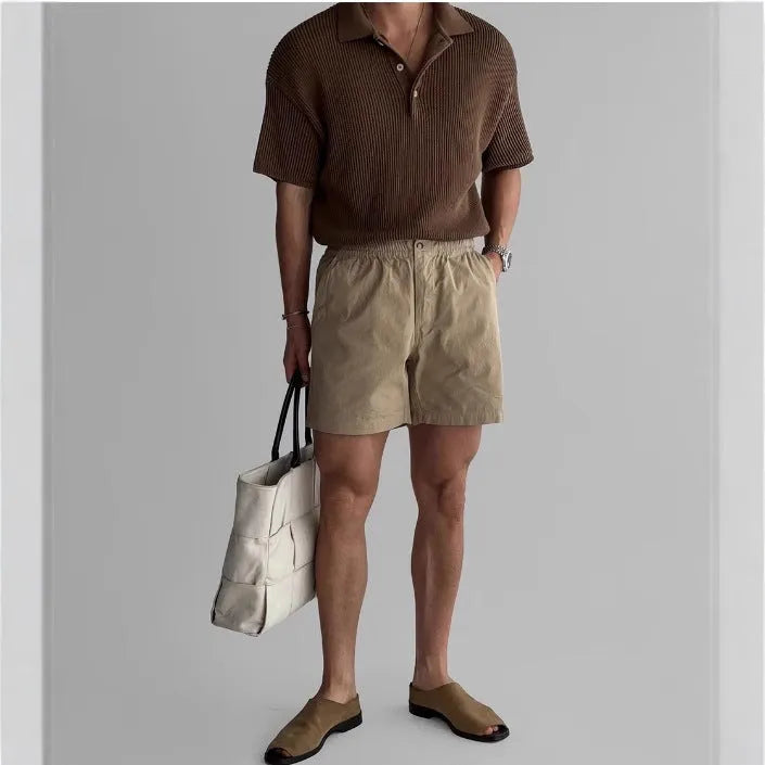 Man's loose-fit cotton sports shorts in black, showing elastic waistband with drawstring.