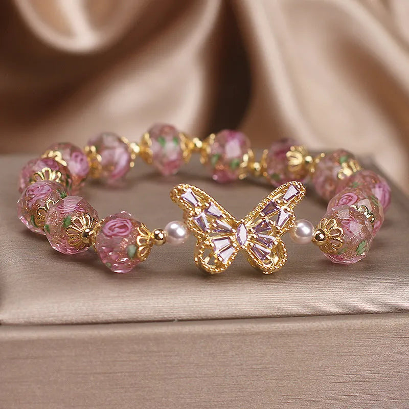 Pink crystal cherry blossom butterfly bracelet with hollow zircon accents on white background