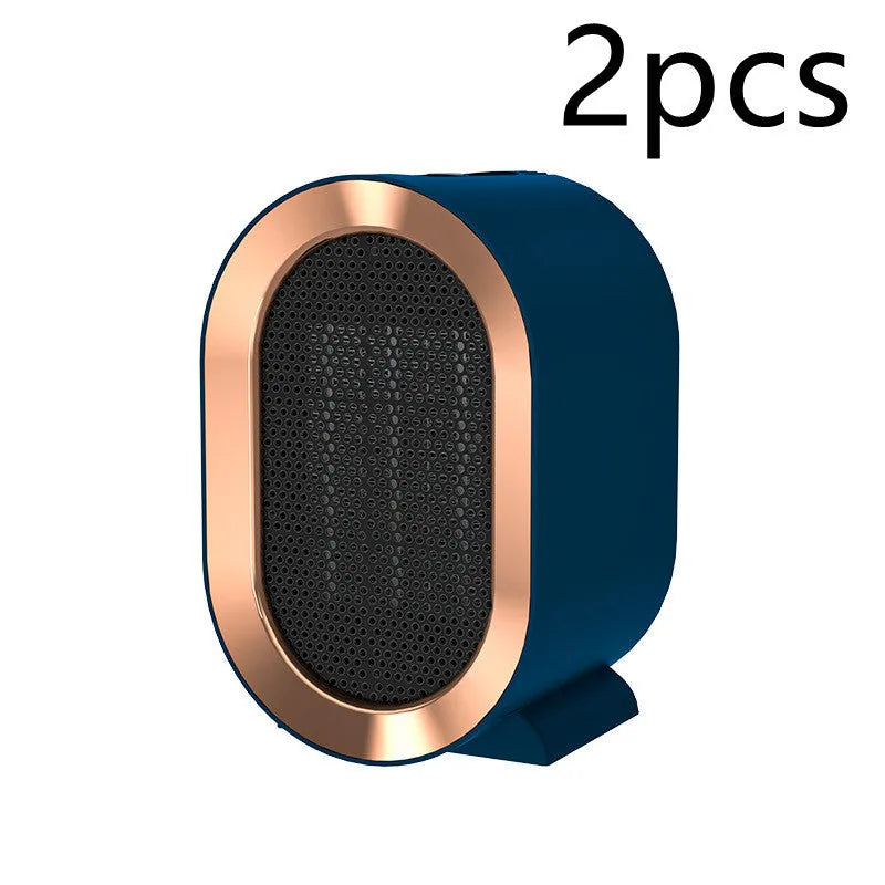 Compact desktop ceramic fan heater in black on a wooden desk.