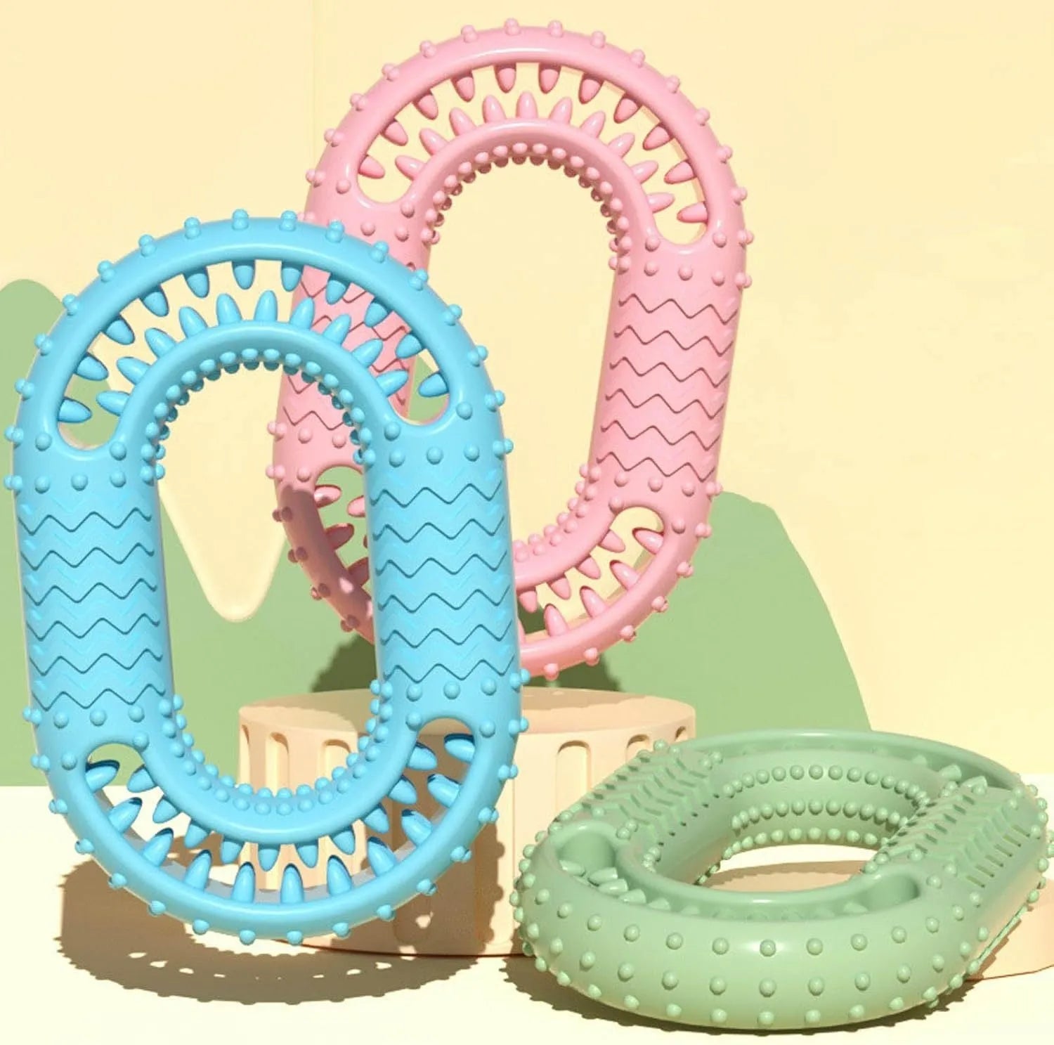 Blue, green, and pink O-ring shaped heavy chew resistant dog toy for aggressive chewers.