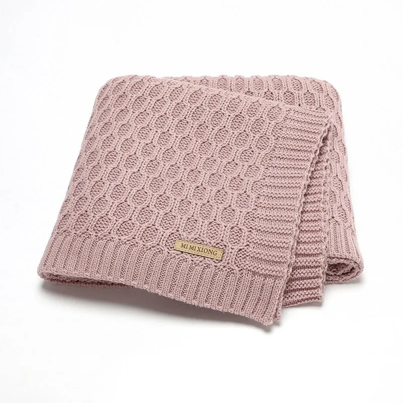 Solid colour baby blanket with raised 3D line texture, shown in beige khaki colour, laid flat to show 70cm by 90cm size.