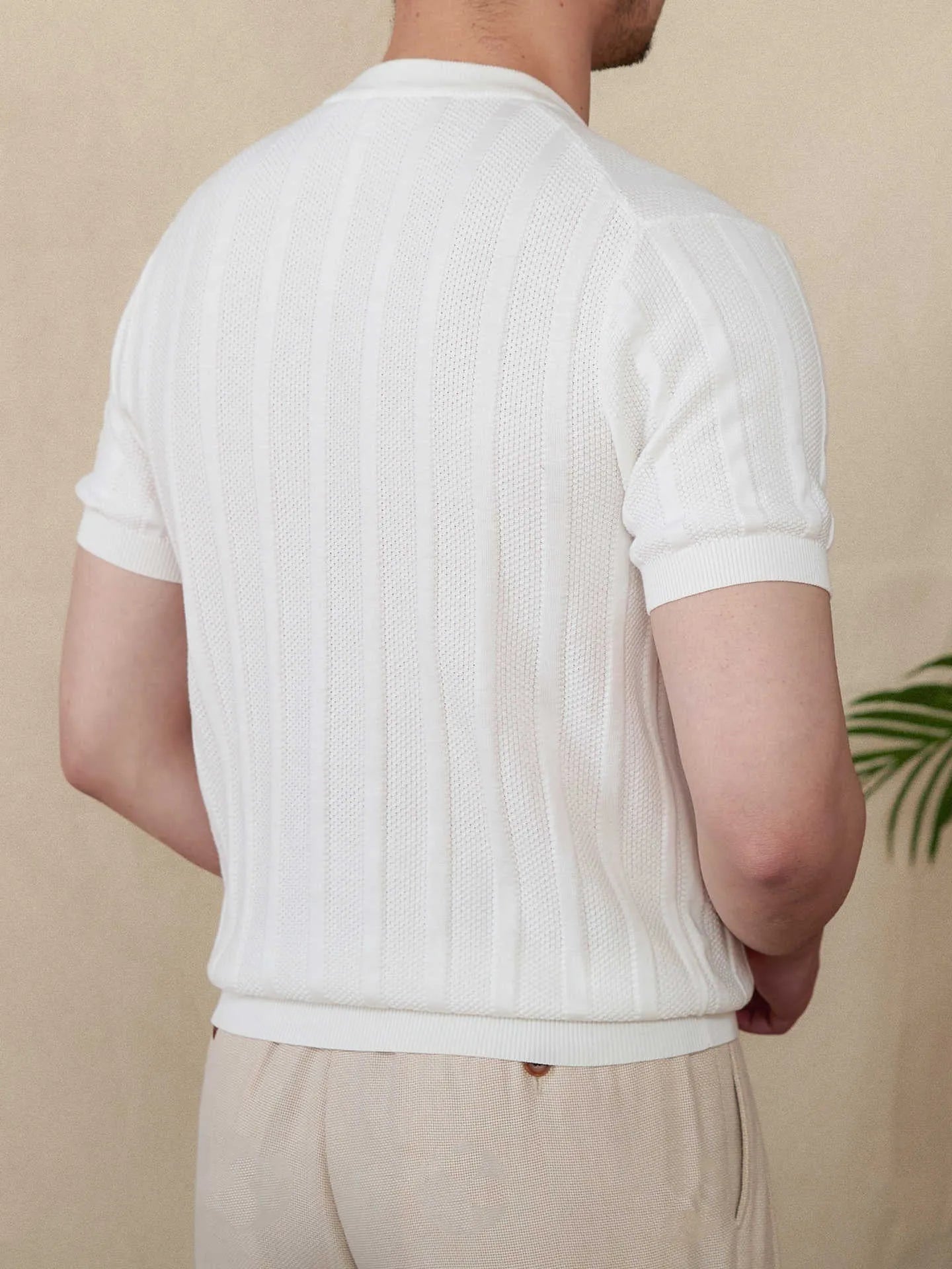 Men's creamy-white cotton short-sleeved T-shirt with a Henry collar and subtle sunken stripe pattern laid flat.